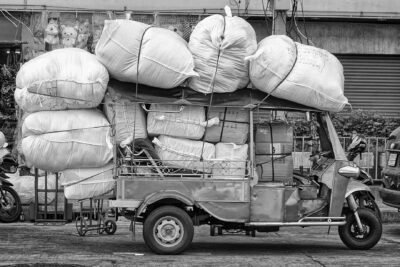 un tuktuk chargé de gros ballots